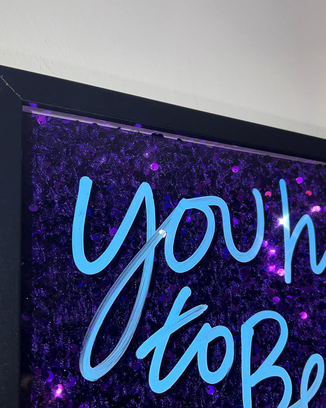 Believe.  Blue ink over deep purple sequins. Medium.