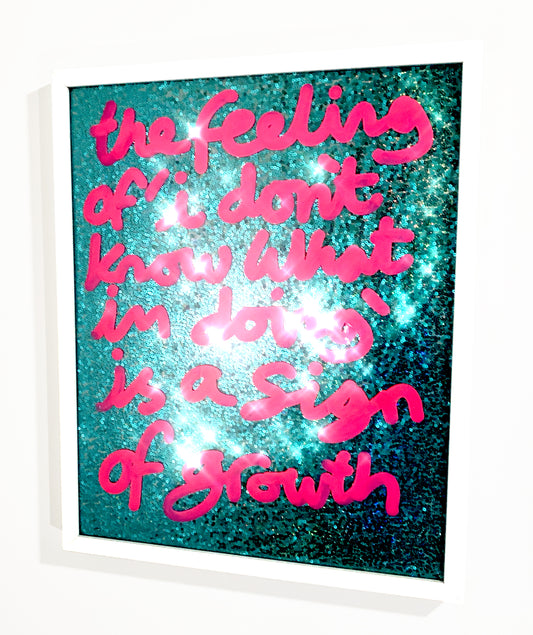 Sign of growth, neon pink ink over aqua green/blue sequins.